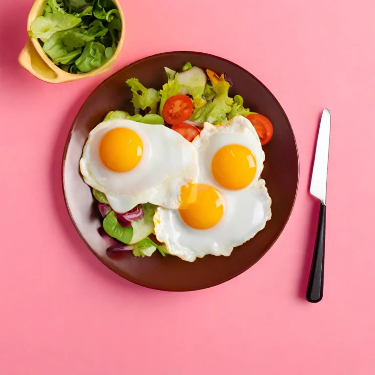 Huevos fritos con ensalada y fondo rosa